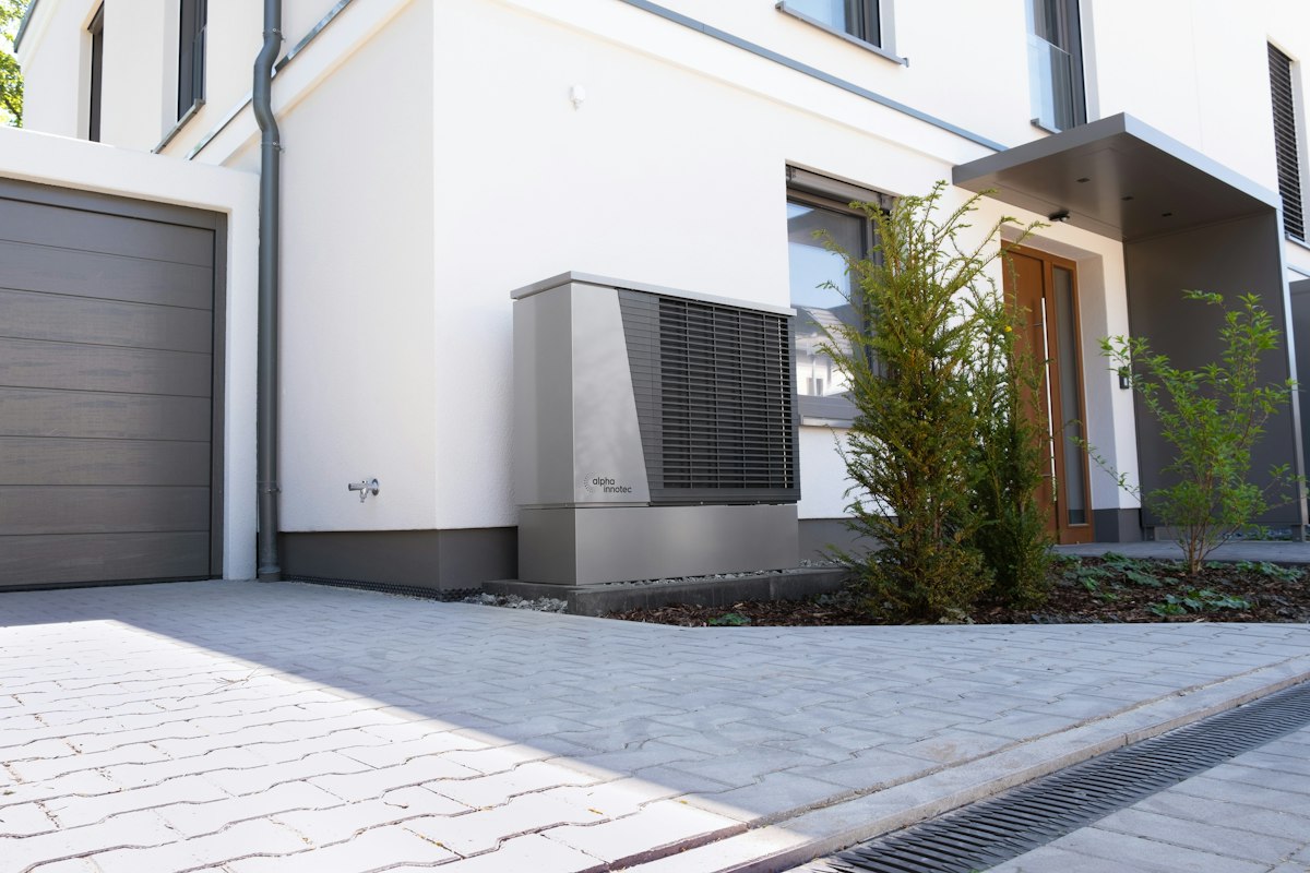 Electric heat pump unit installed outside a modern home